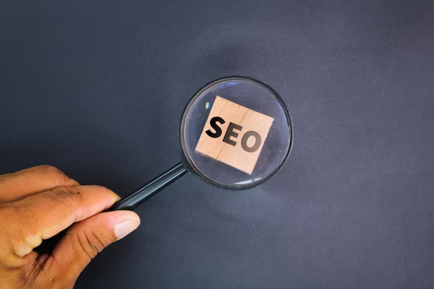 The hand holds a magnifying glass that is aimed at the SEO cube