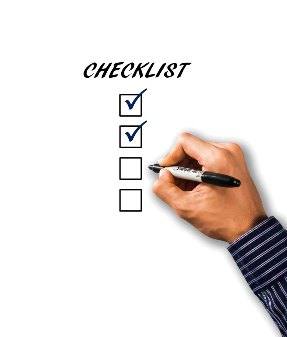 a hand with a marker ticking boxes of a checklist